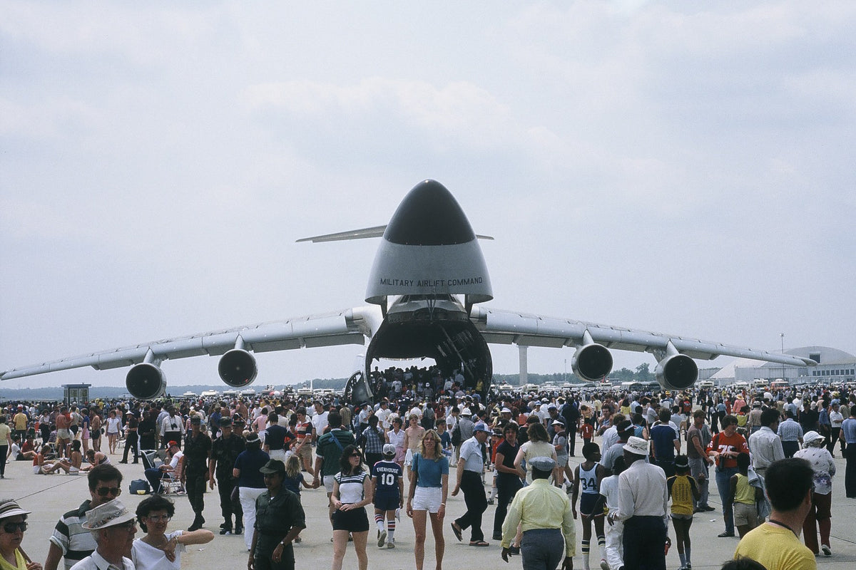 The raised nose of a C-5 Galaxy cargo aircraft opens above a crowd of air-show visitors.